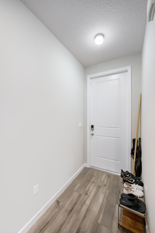 entryway featuring light hardwood / wood-style floors and a textured ceiling