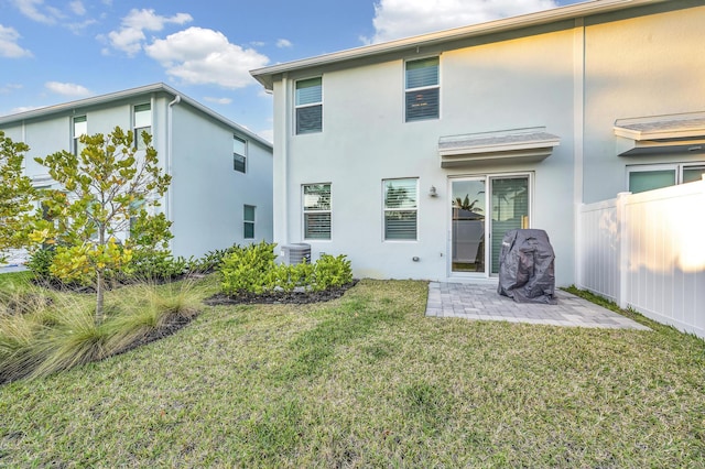 rear view of property featuring central AC unit, a patio area, and a yard