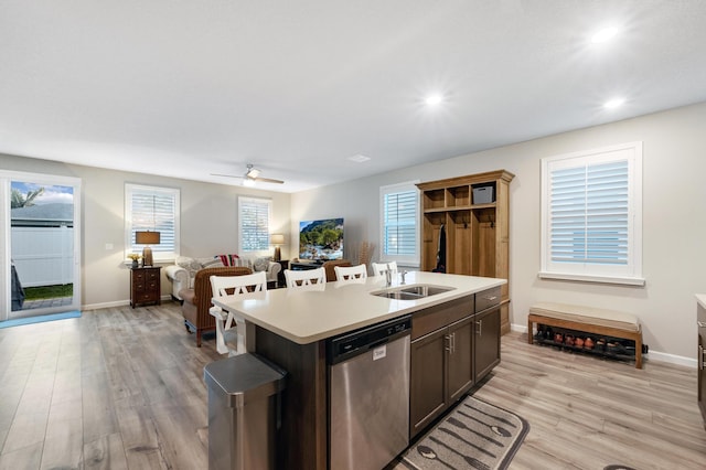 kitchen featuring sink, light hardwood / wood-style flooring, stainless steel dishwasher, an island with sink, and dark brown cabinets