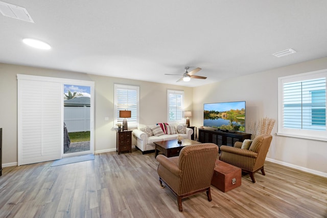 living room with light wood-type flooring and ceiling fan