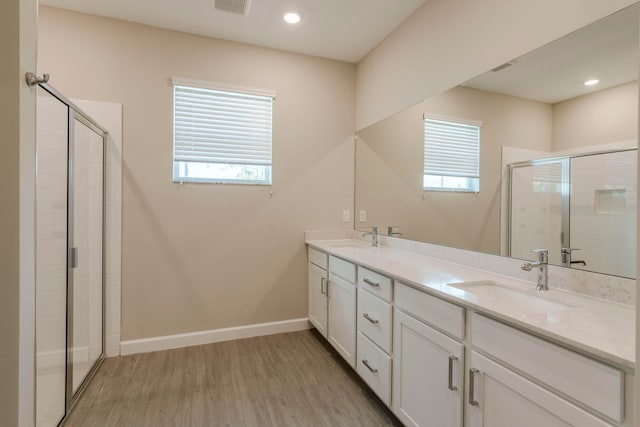 bathroom with hardwood / wood-style flooring, vanity, a shower with door, and a wealth of natural light