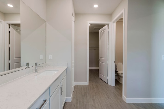 bathroom featuring vanity, toilet, and hardwood / wood-style flooring