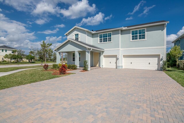 view of front facade with a garage, a porch, and a front lawn