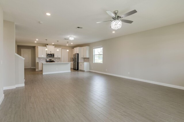 unfurnished living room featuring light hardwood / wood-style flooring and ceiling fan