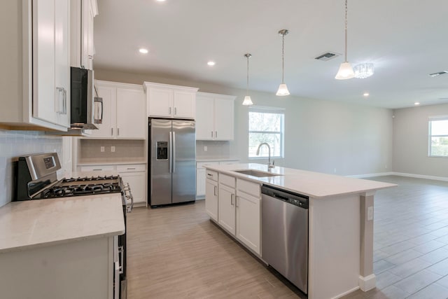 kitchen featuring white cabinets, stainless steel appliances, sink, and a healthy amount of sunlight