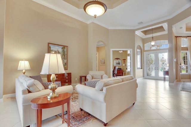 tiled living room with ornamental molding, a towering ceiling, and french doors