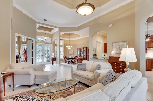 tiled living room featuring a towering ceiling, ceiling fan with notable chandelier, a raised ceiling, and crown molding