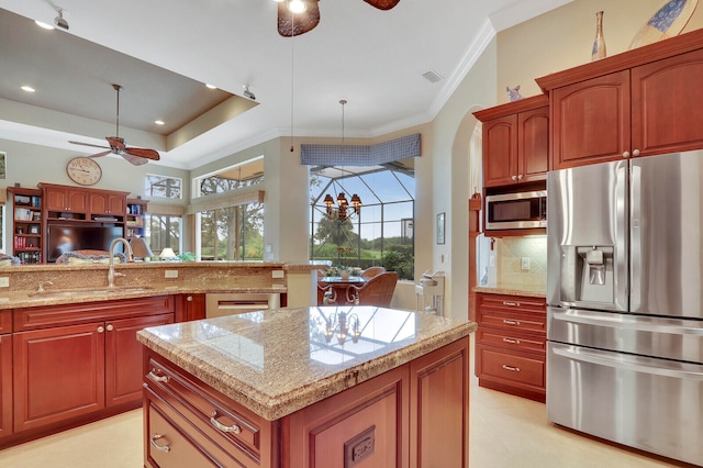 kitchen featuring a kitchen island, stainless steel appliances, backsplash, decorative light fixtures, and ceiling fan