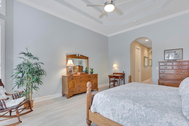 bedroom featuring ceiling fan, light wood-type flooring, crown molding, and a tray ceiling