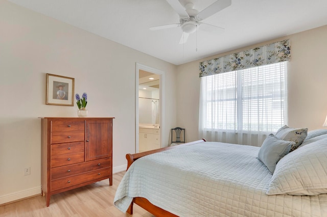 bedroom with light hardwood / wood-style flooring, ensuite bath, and ceiling fan