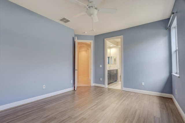 unfurnished bedroom featuring ceiling fan, light hardwood / wood-style flooring, and ensuite bath