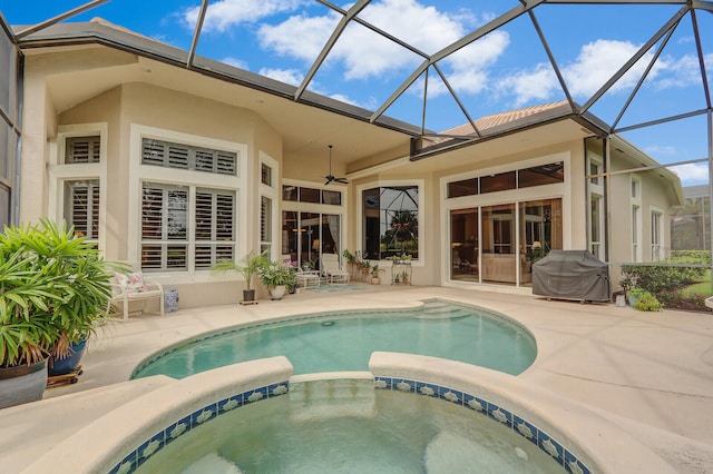 view of swimming pool with a lanai, a patio, an in ground hot tub, ceiling fan, and grilling area