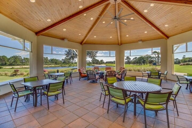 sunroom with ceiling fan, wood ceiling, and lofted ceiling with beams