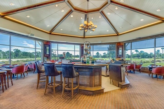 bar featuring an inviting chandelier, high vaulted ceiling, and wooden ceiling