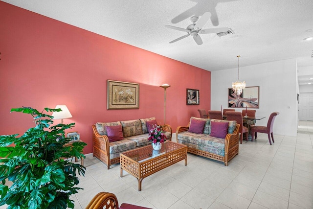 living room featuring a textured ceiling and ceiling fan with notable chandelier