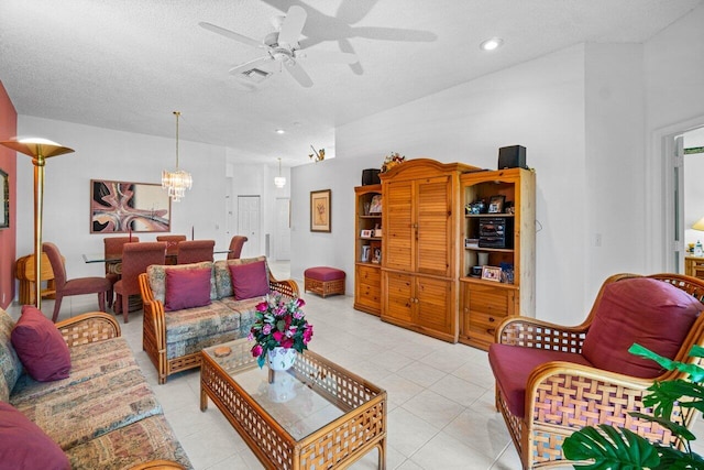 tiled living room featuring ceiling fan with notable chandelier and a textured ceiling