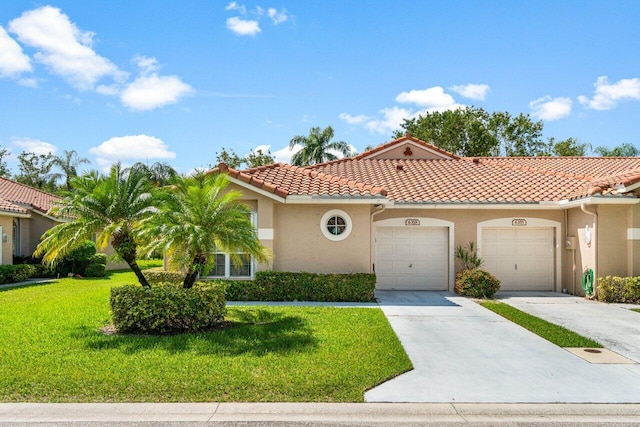 mediterranean / spanish house featuring a front lawn and a garage