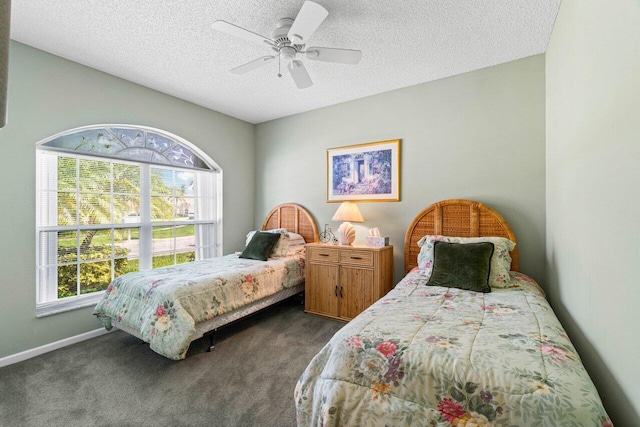 carpeted bedroom with ceiling fan and a textured ceiling