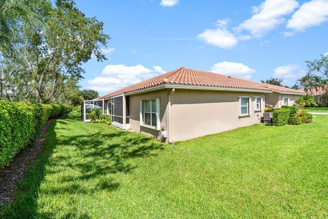 rear view of house featuring a lawn and central air condition unit