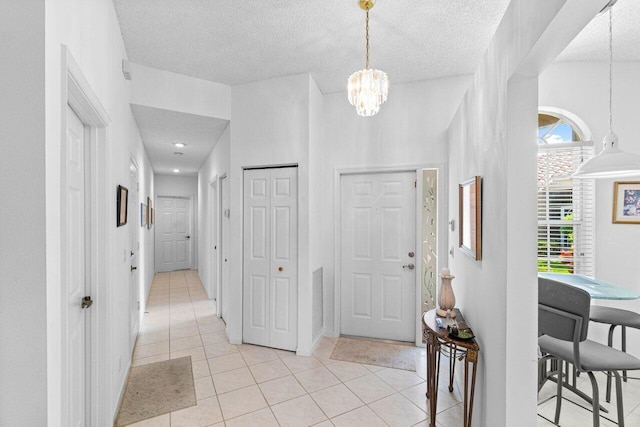 tiled foyer featuring a textured ceiling and a high ceiling