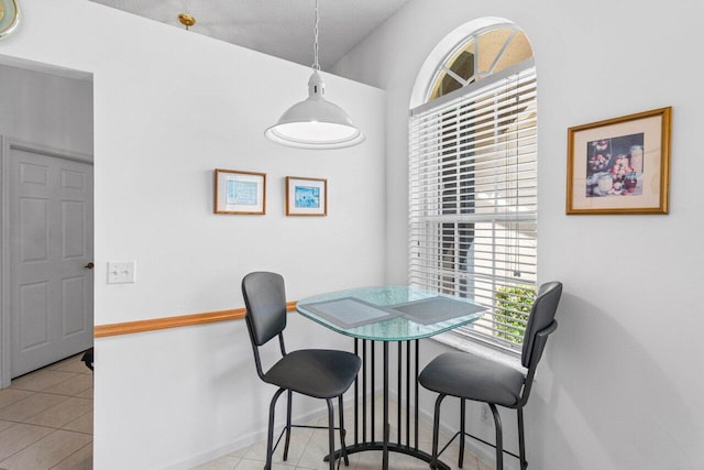 dining space with a textured ceiling and light tile patterned flooring