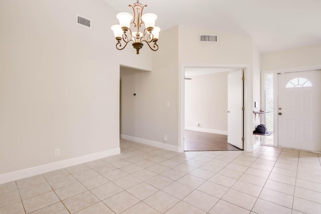 interior space featuring light tile patterned floors, a chandelier, and high vaulted ceiling