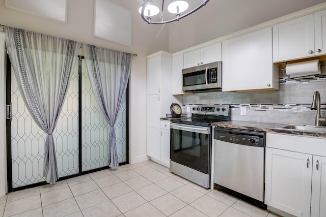 kitchen featuring white cabinets, appliances with stainless steel finishes, sink, backsplash, and light tile patterned floors