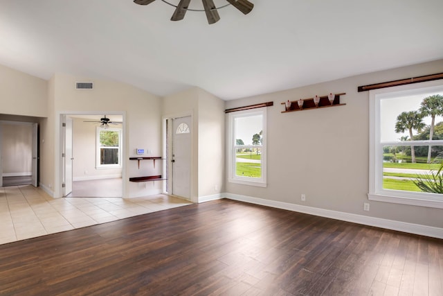 empty room with vaulted ceiling, ceiling fan, and hardwood / wood-style flooring