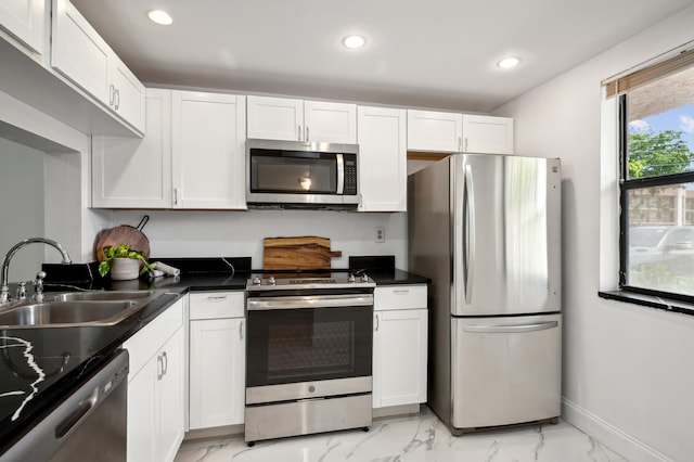 kitchen with stainless steel appliances, white cabinetry, and sink