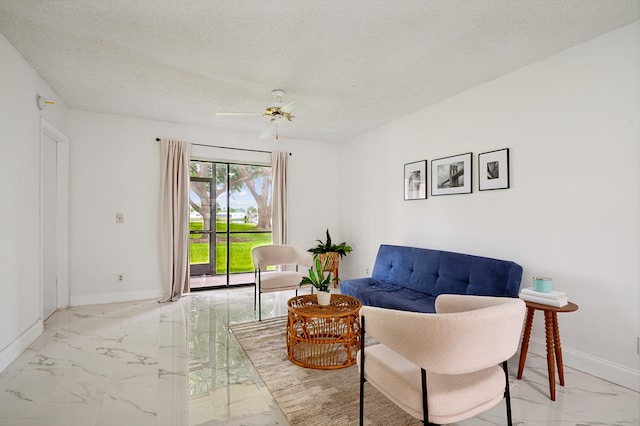 living room featuring a textured ceiling and ceiling fan