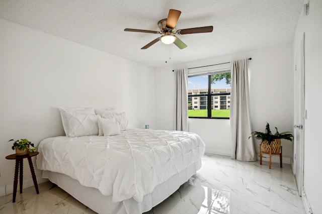 bedroom featuring ceiling fan and a textured ceiling