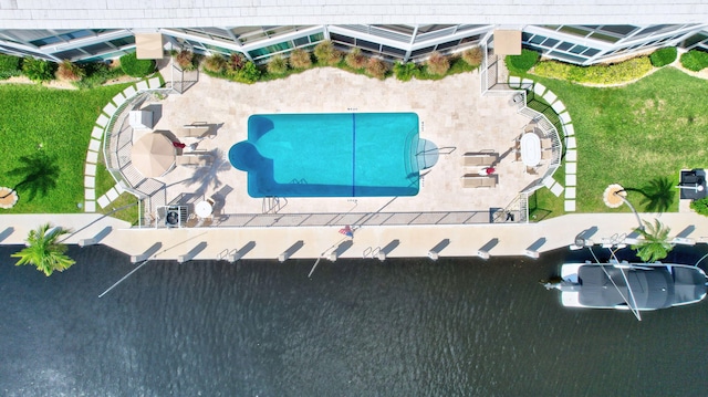 view of pool with a yard, a patio area, and a water view