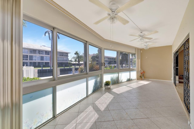 unfurnished sunroom with a water view and ceiling fan