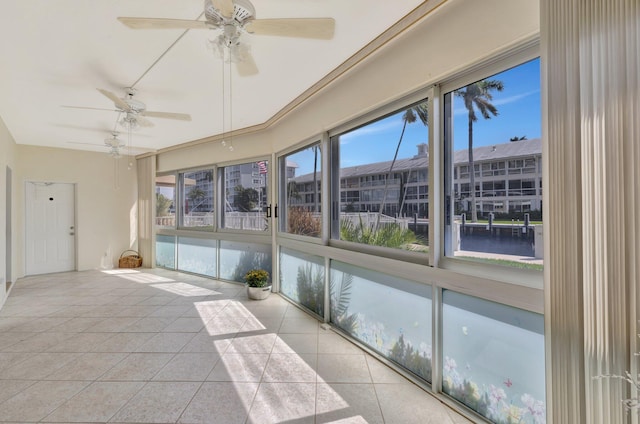 unfurnished sunroom with a water view and ceiling fan