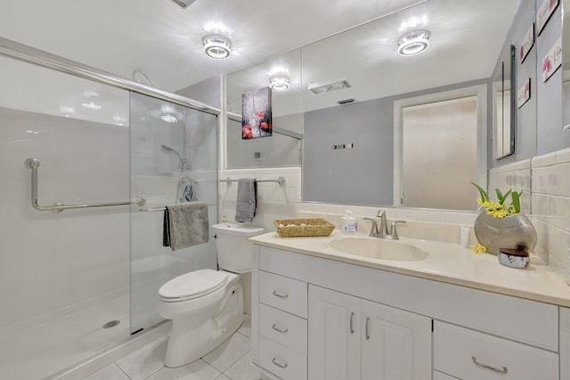 bathroom with tile patterned floors, toilet, vanity, tile walls, and an enclosed shower