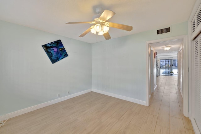 empty room featuring ceiling fan and light wood-type flooring