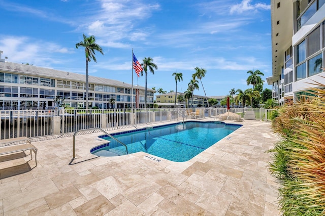 view of swimming pool featuring a patio area and a water view