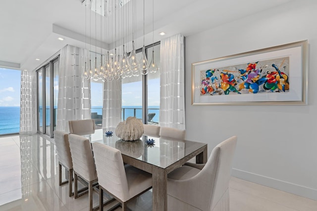 tiled dining space with a water view and a chandelier