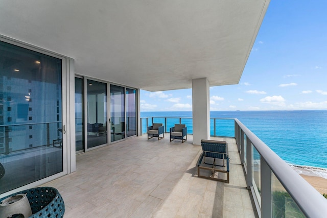 balcony with a water view and a beach view