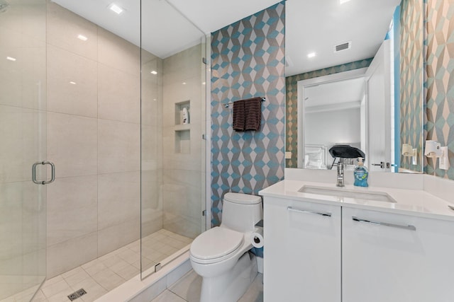 bathroom with tile walls, a shower with shower door, vanity, and toilet