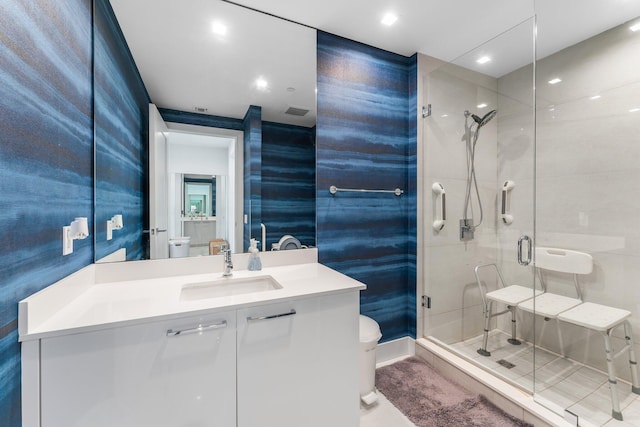 bathroom featuring tile patterned flooring, vanity, toilet, and a shower with door