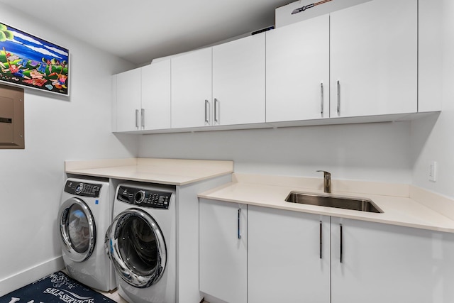 clothes washing area with washing machine and dryer, sink, electric panel, and cabinets