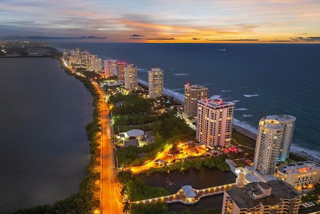 aerial view at dusk featuring a water view