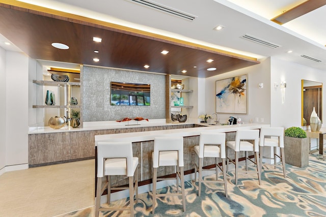 kitchen featuring wood ceiling, kitchen peninsula, and a breakfast bar area