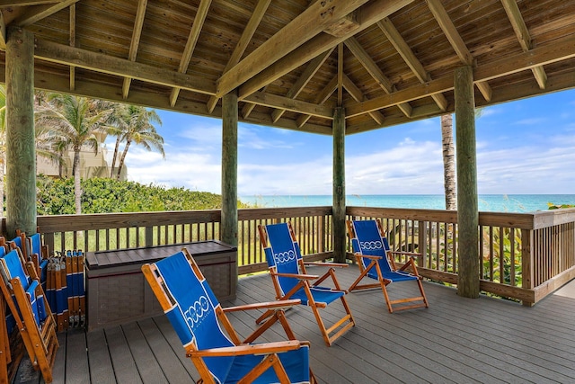 wooden terrace with a view of the beach and a water view