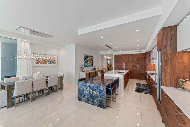 5000 N Ocean Dr Unit 1003, Singer Island, FL 33404 - kitchen with modern cabinets, light tile patterned floors, a sink, a spacious island, and recessed lighting
