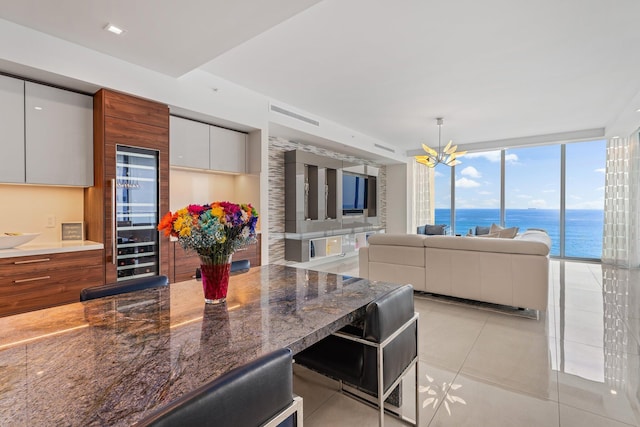 5000 N Ocean Dr Unit 1003, Singer Island, FL 33404 - kitchen featuring modern cabinets, light tile patterned floors, a chandelier, a kitchen breakfast bar, and beverage cooler