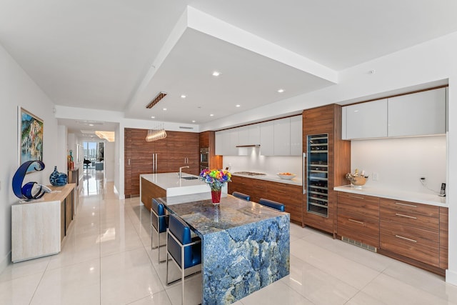 kitchen with a large island, white cabinetry, pendant lighting, and gas cooktop