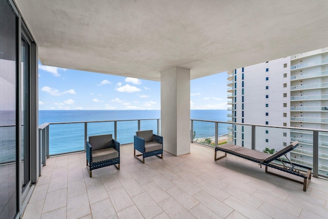 view of patio featuring a balcony and a water view