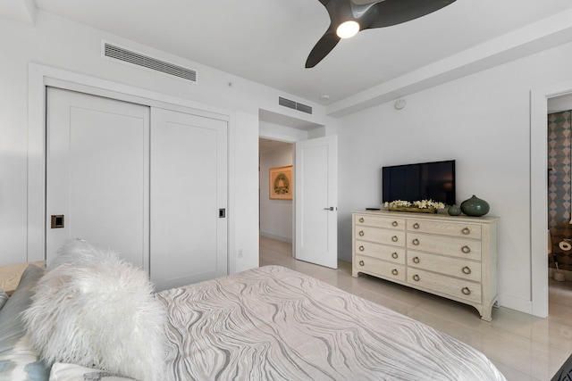 bedroom featuring light tile patterned floors, ceiling fan, and a closet